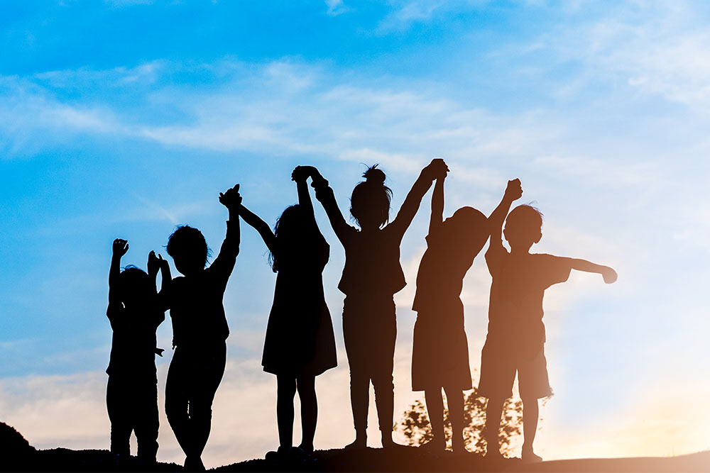 kids cheering on top of a hill