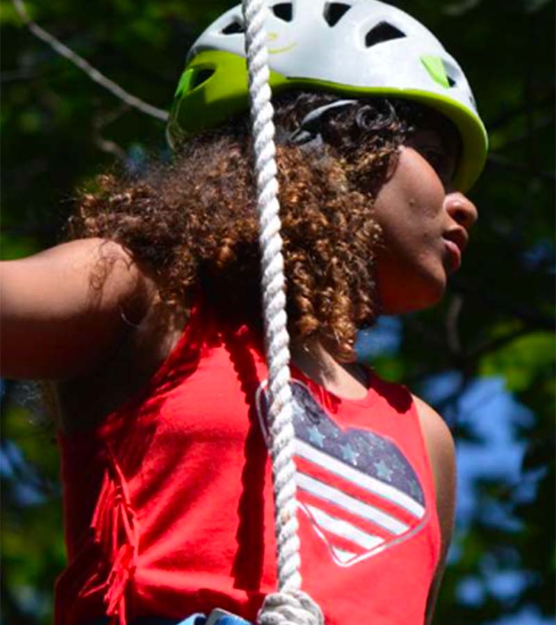 Girl wearing helmet doing outdoor activity in camp hope